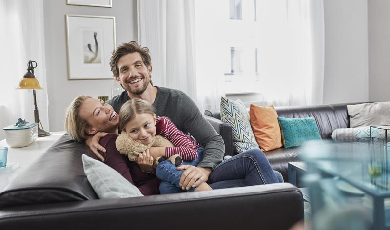 Happy family sitting on couch at home